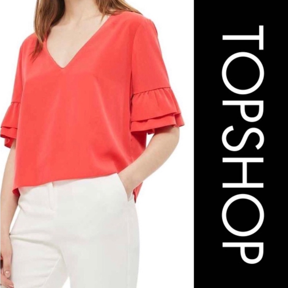 Topshop orange top with ruffle sleeves and black bow